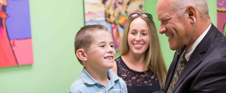 Doctor smiling with a young boy and his mother