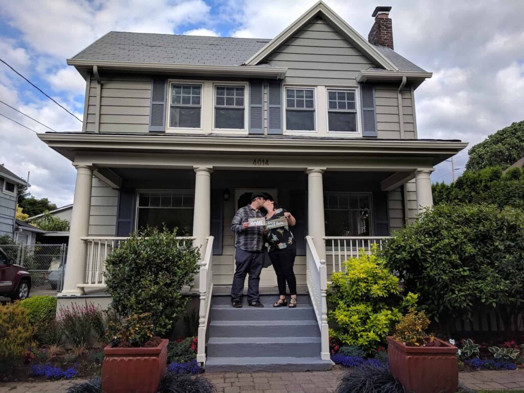 Couple embracing on the front steps of a house